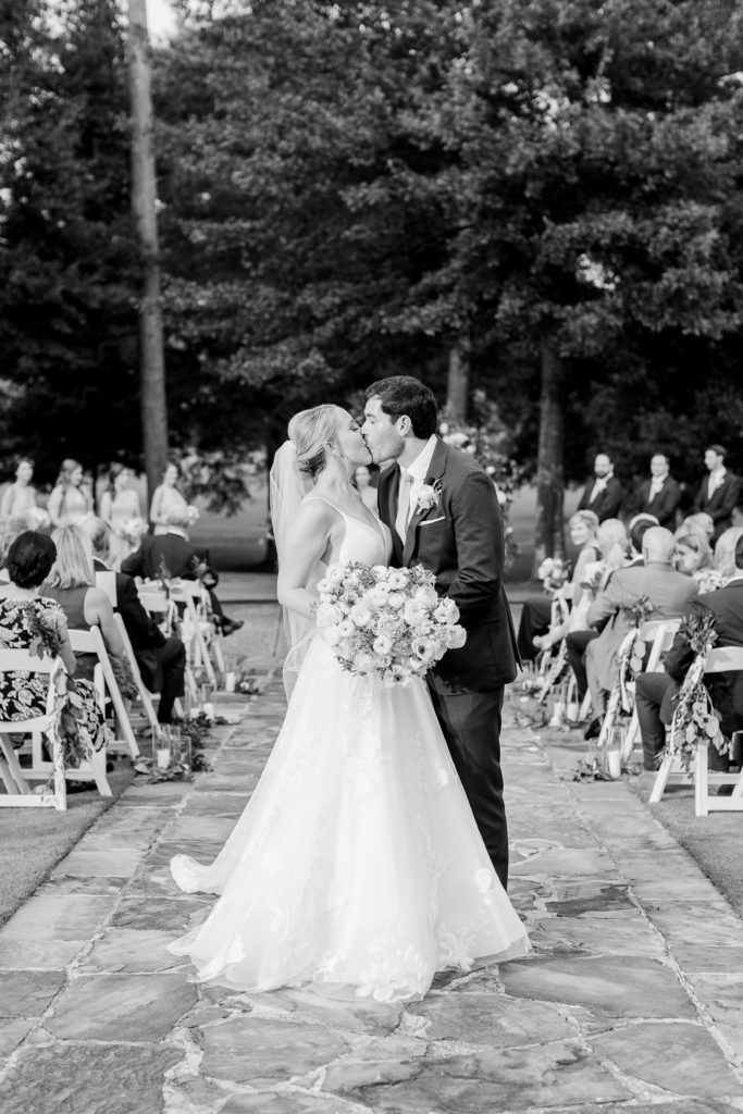 bride and groom kiss at wedding ceremony