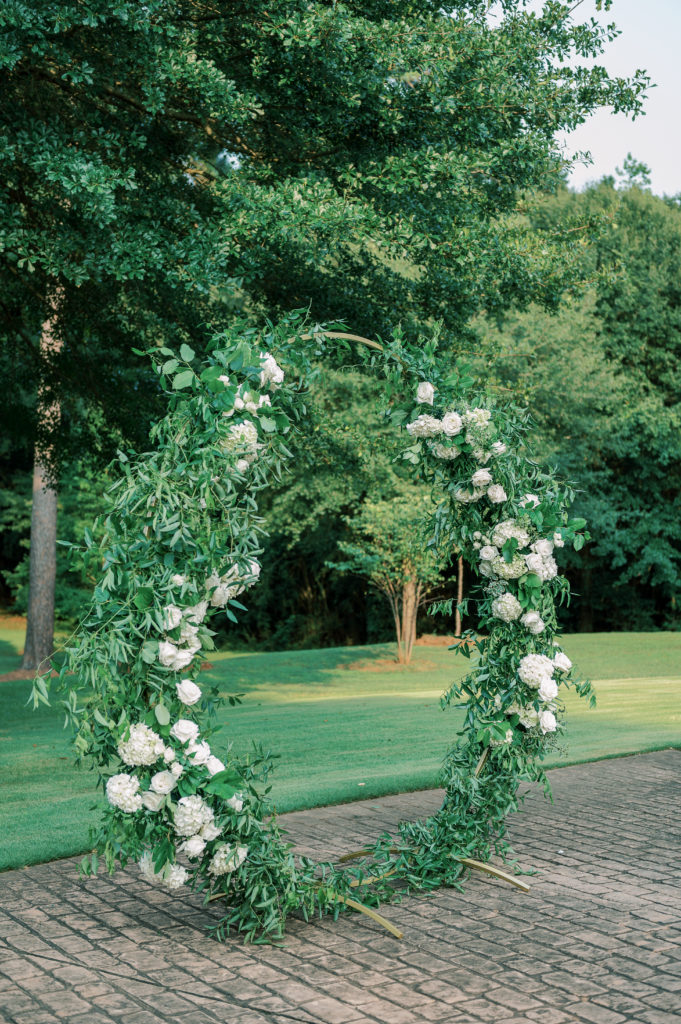 wedding ceremony circular arch with greenery and white flowers