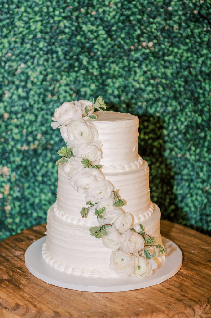 3 tiered white wedding cake with white flowers
