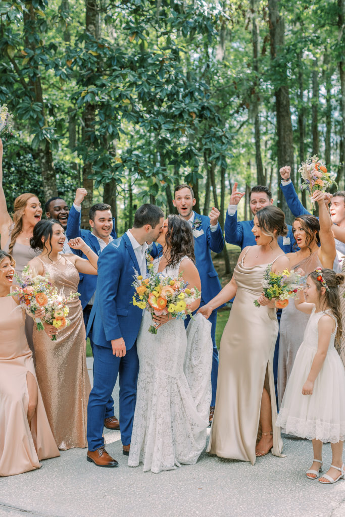 bride and groom kissing surrounded by bridesmaids and groomsmen