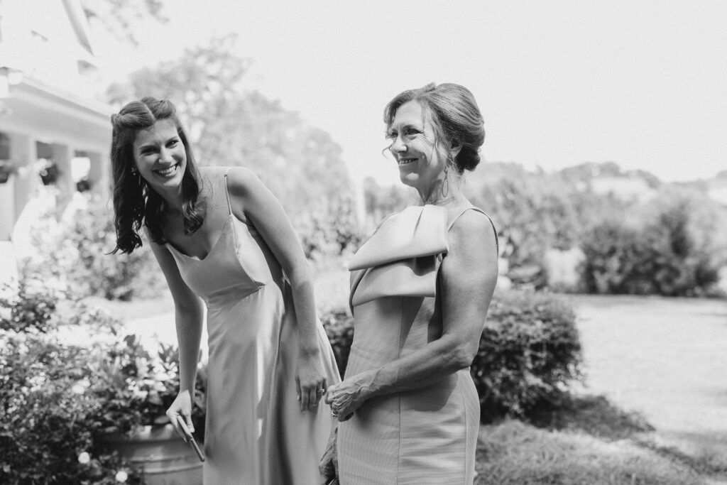 mom and sister of the bride laughing