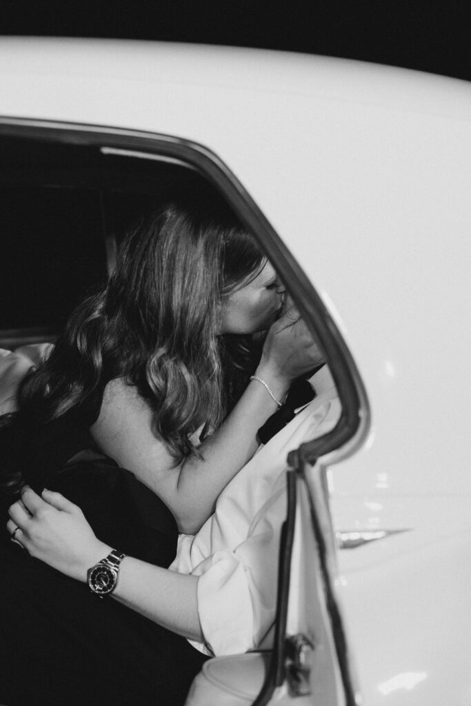 bride and groom kissing in a car
