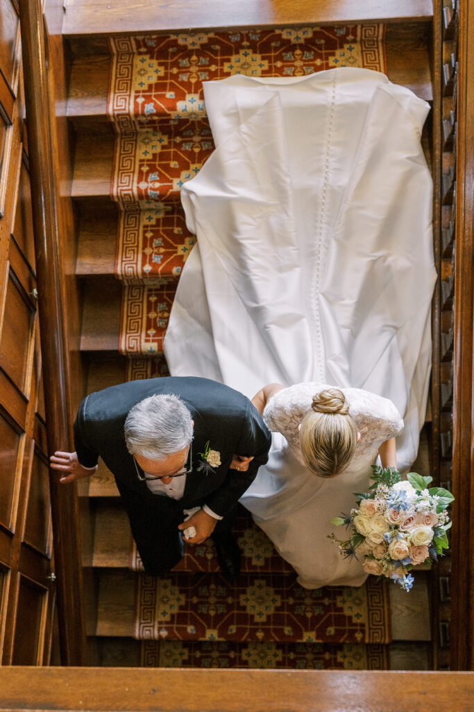 father walking his bride down the stairs