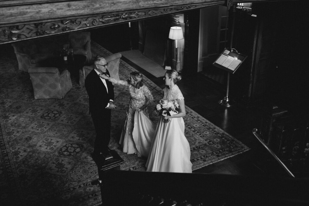 a bride and her parents from above in the stairwell