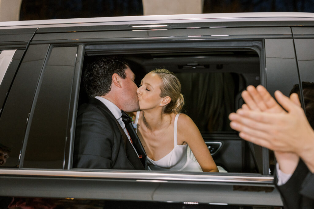 bride and groom kissing in limo
