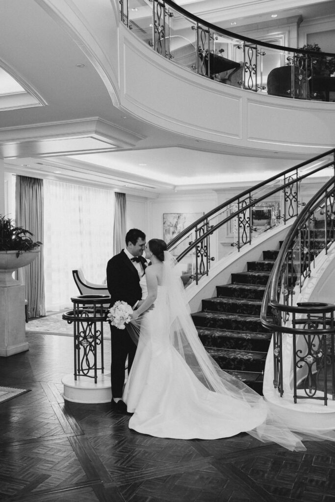 bride and groom kissing in front of the stairwell
