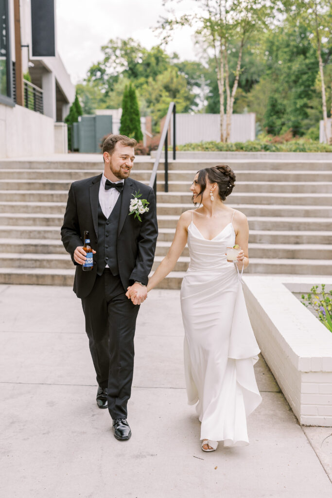 bride and groom walking down the stairs with drinks