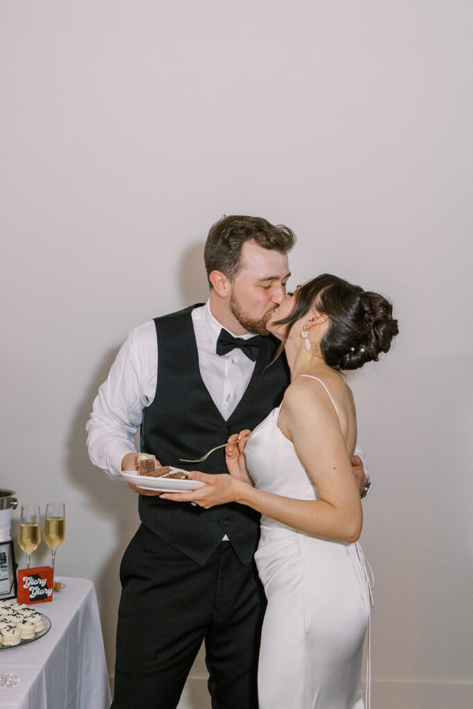 bride and groom kissing with cake