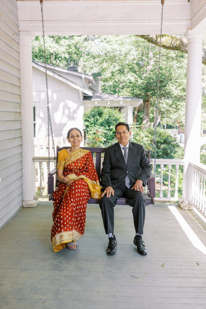 groom's parents sitting on a porch swing