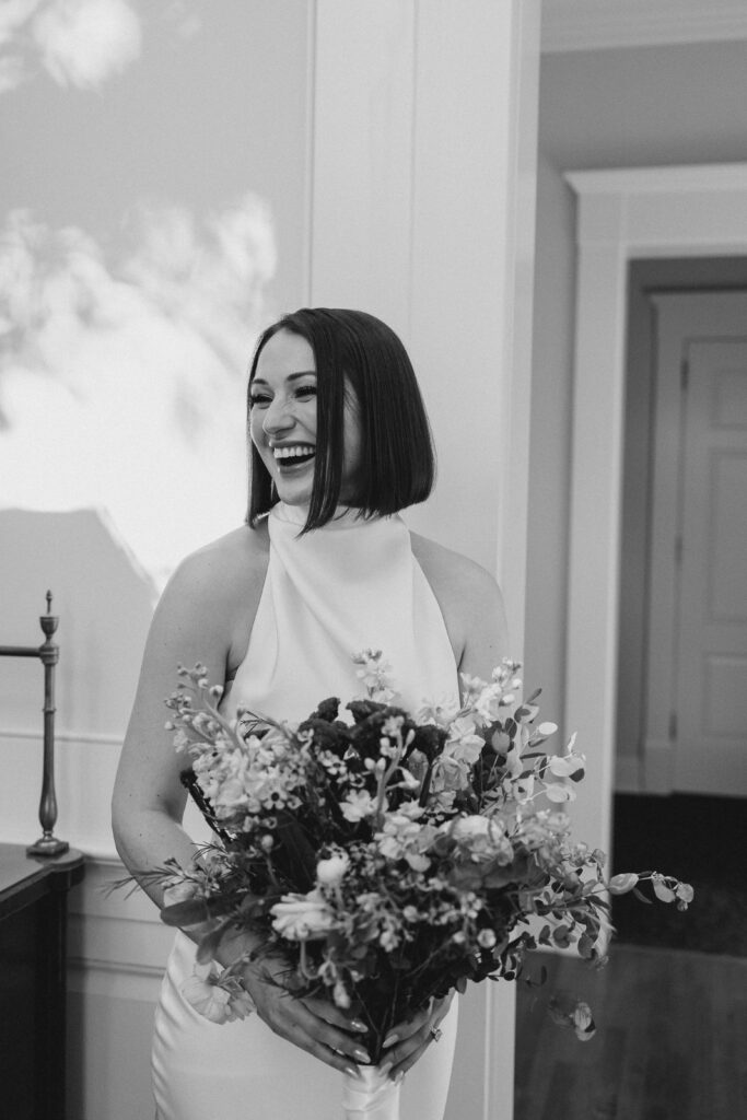 bride laughing with her bouquet