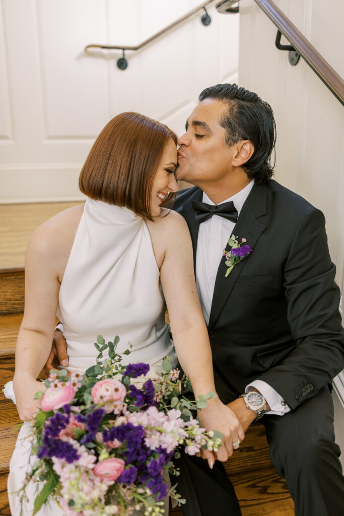 groom kissing bride's forehead