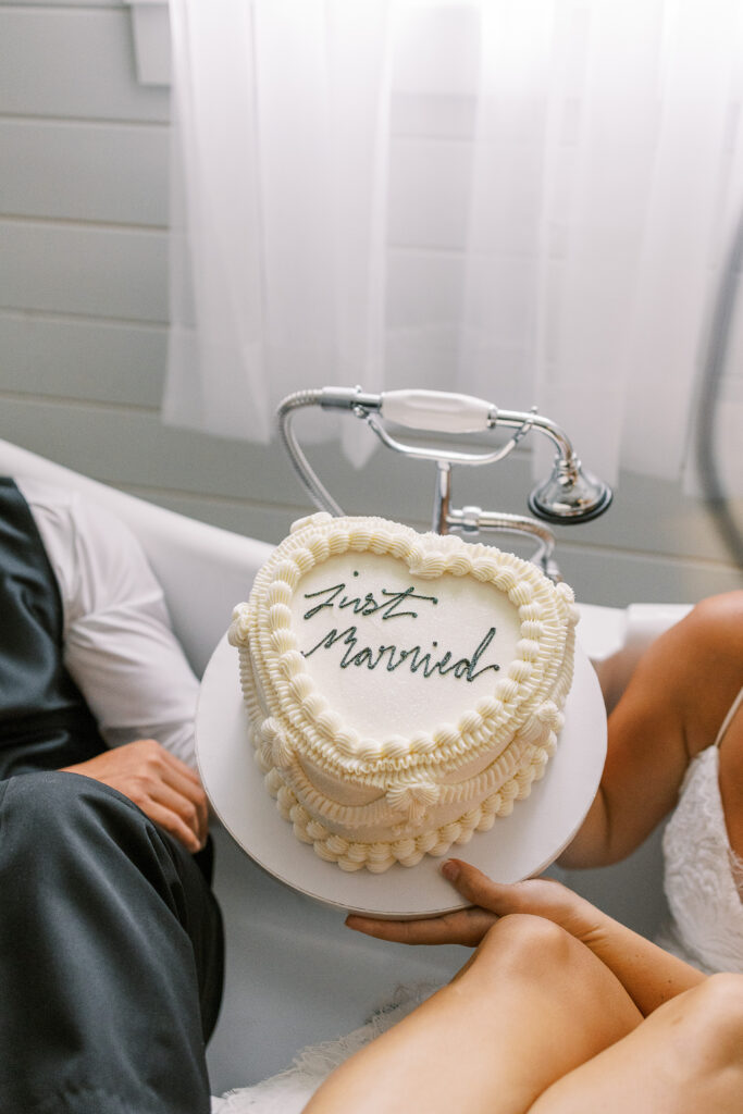 bride and groom eating cake in a bath tub