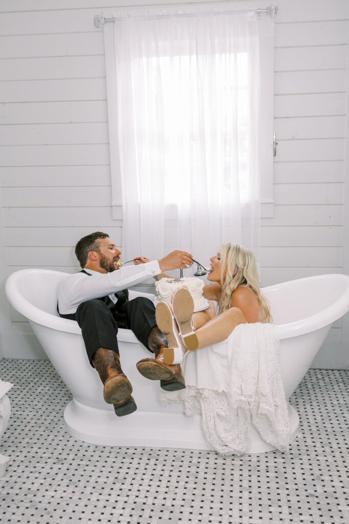 bride and groom eating cake in a bath tub