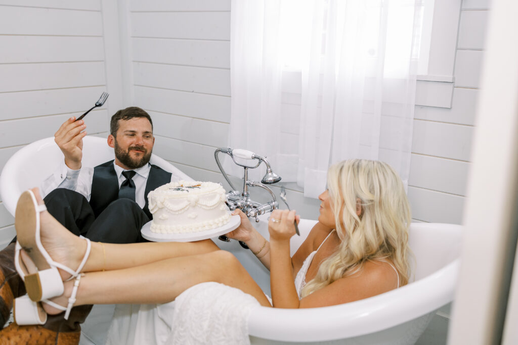 bride and groom eating cake in a bath tub