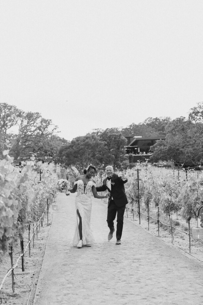 bride and groom dancing through a vineyard in napa valley