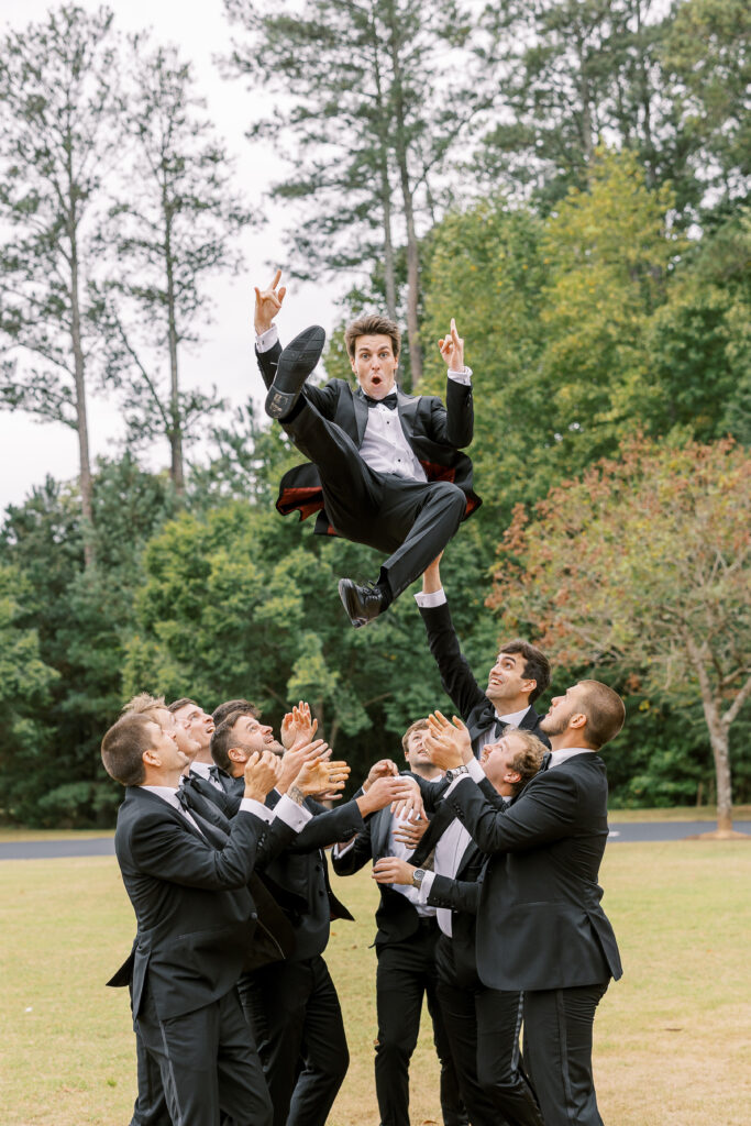 groom being thrown by his groomsmen