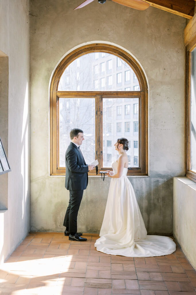 bride and groom reading their vows to each other