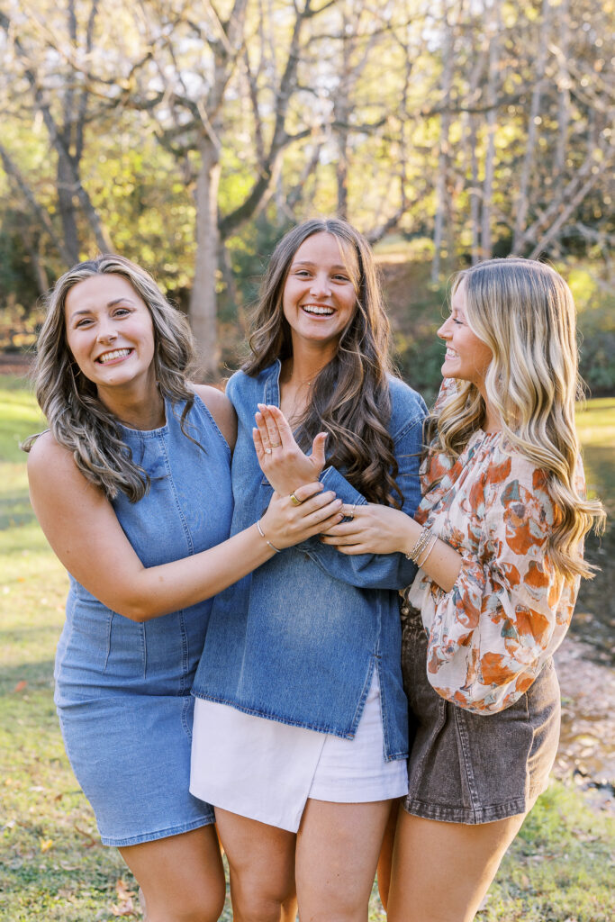 girl showing engagement ring to her sisters and friends