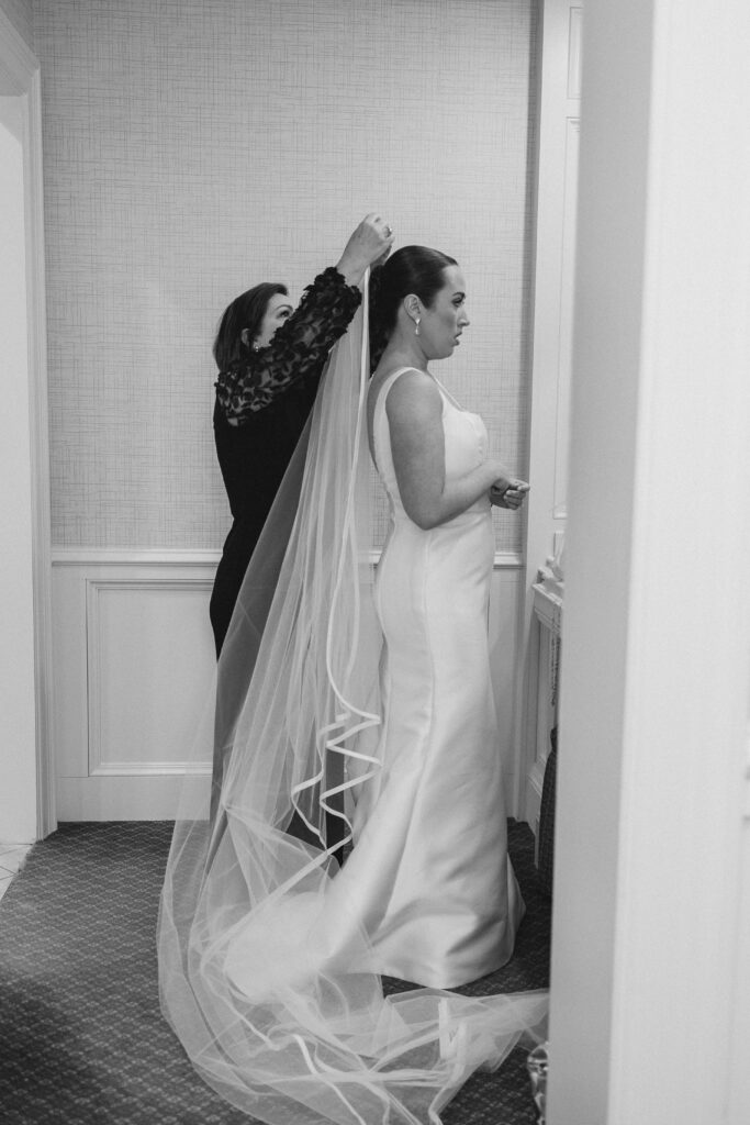 bride's mom putting the veil on the bride