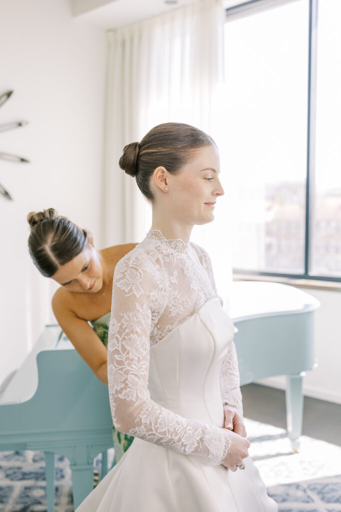 maid of honor adjusting bride's dress