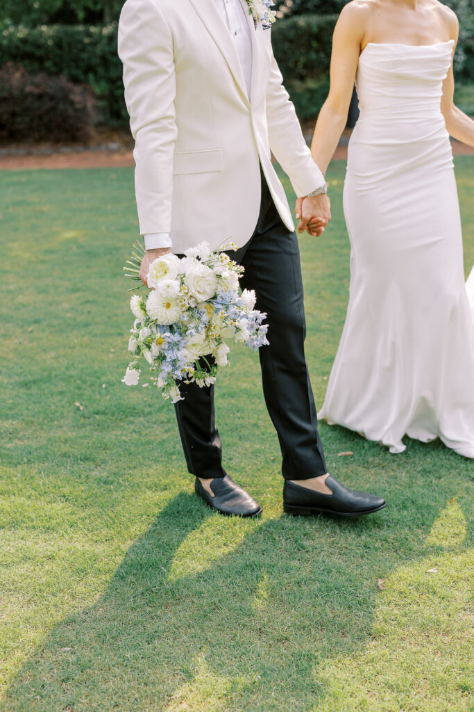 groom carrying bride's bouquet
