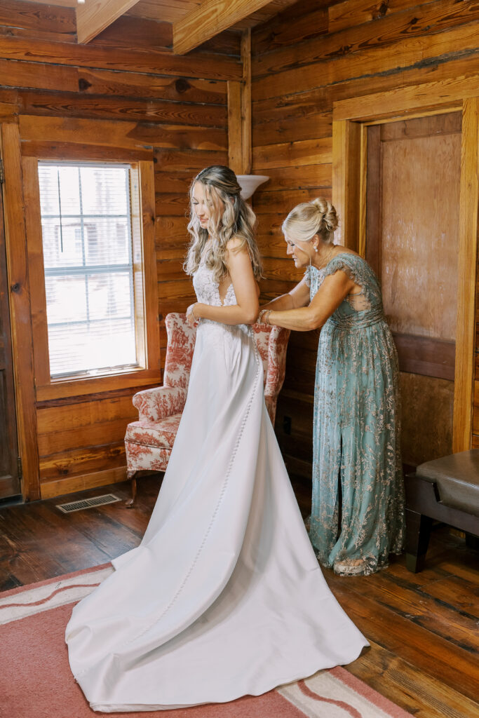 bride's mom helping her dress