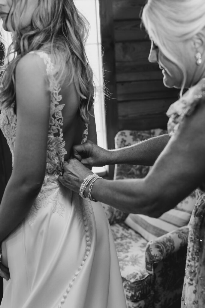 bride's mom helping her dress
