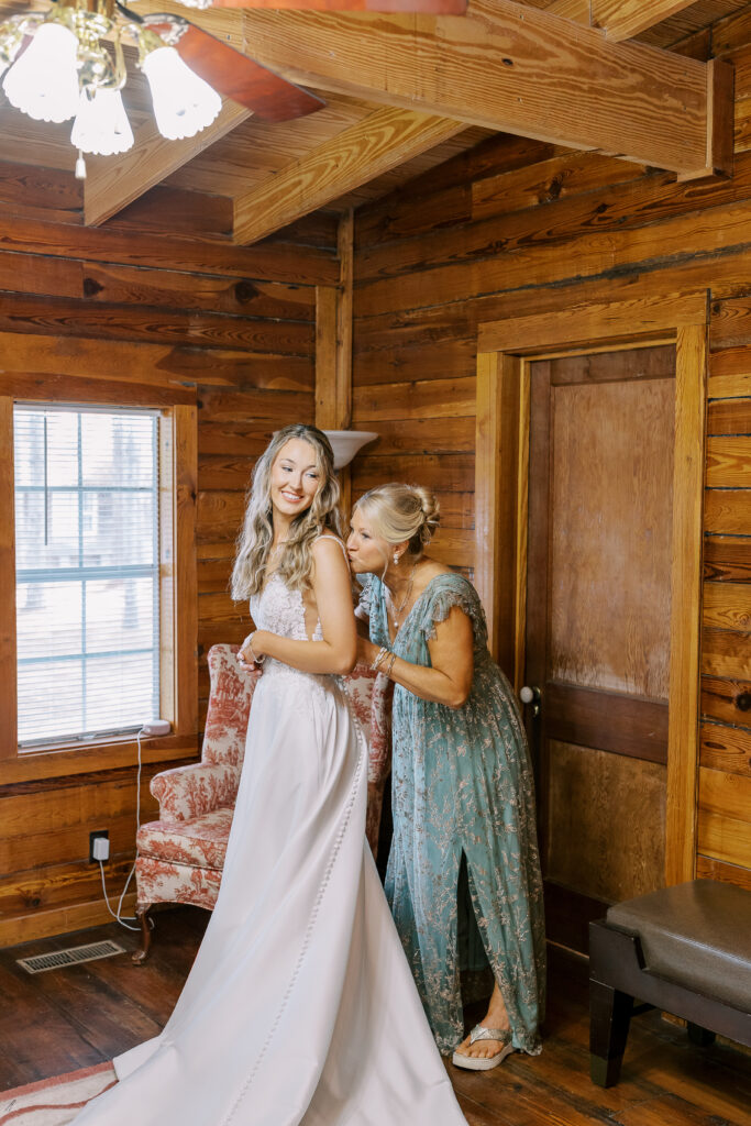 bride's mom helping her dress