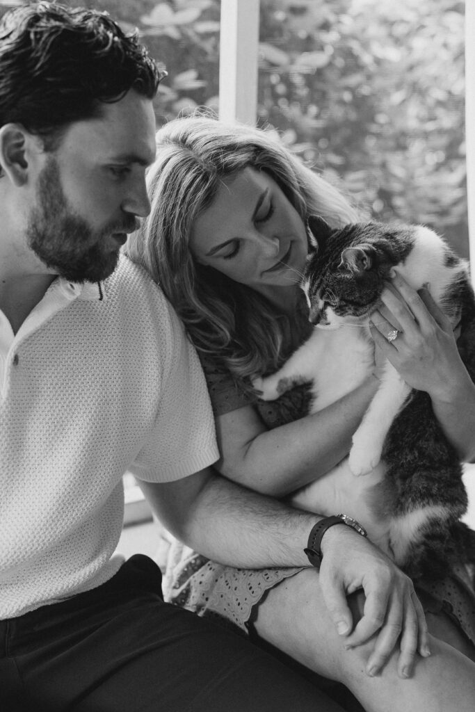an engaged couple with their pet cat