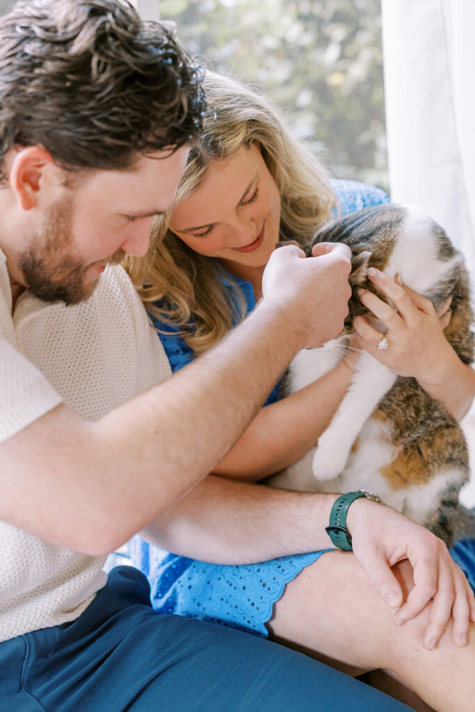 an engaged couple with their pet cat