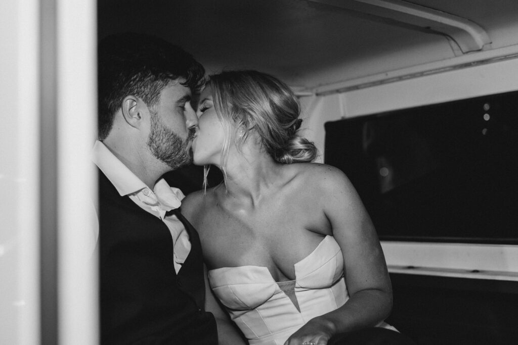 bride and groom kissing in a car
