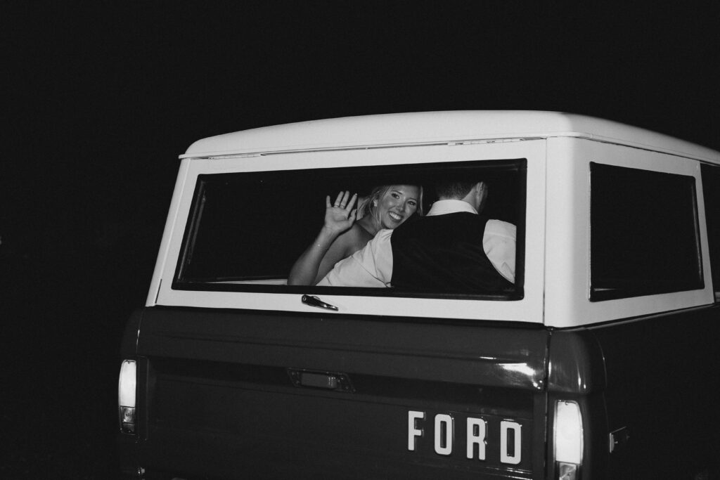 bride waving to guests from car