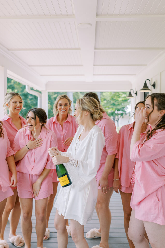bride and bridesmaids popping champagne