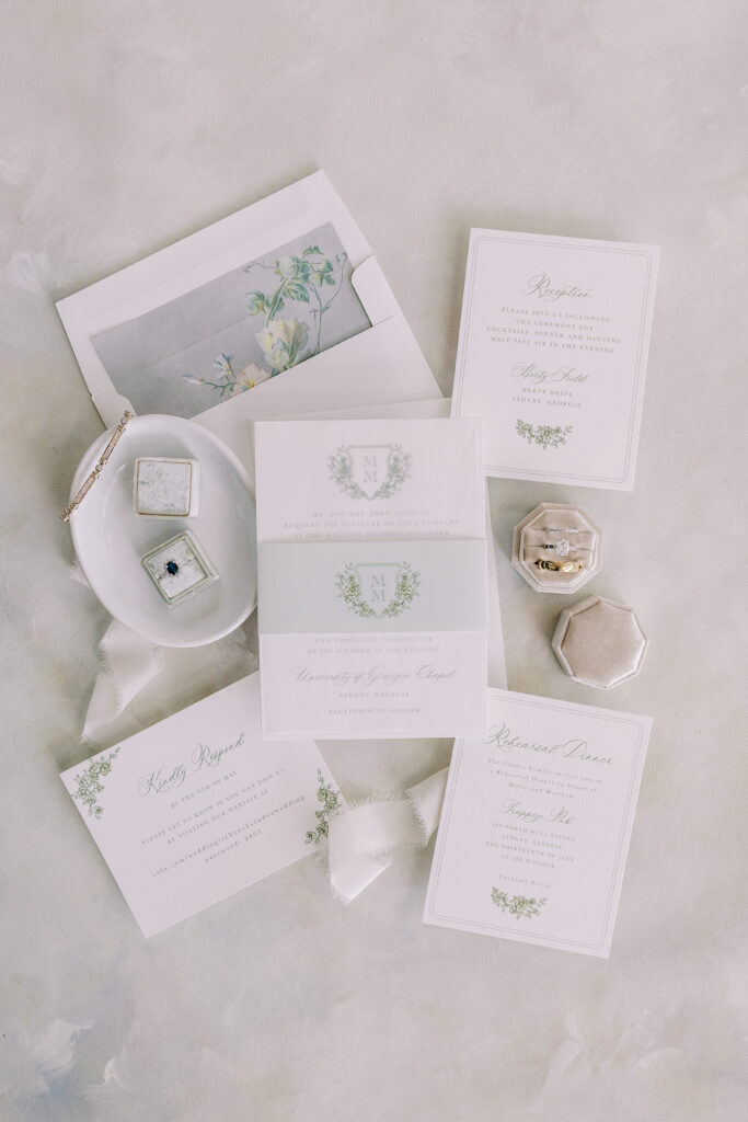 wedding detail flat lay including invitations and rings