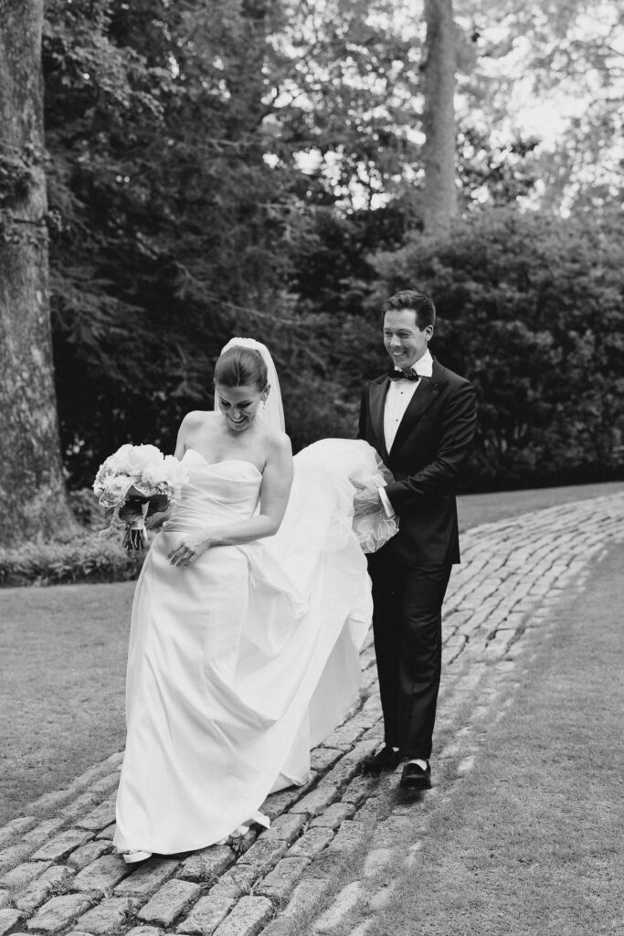 groom carrying bride's train