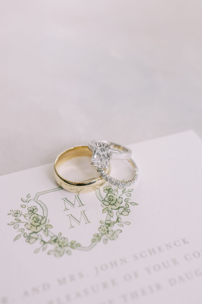 wedding detail flat lay including invitations and rings
