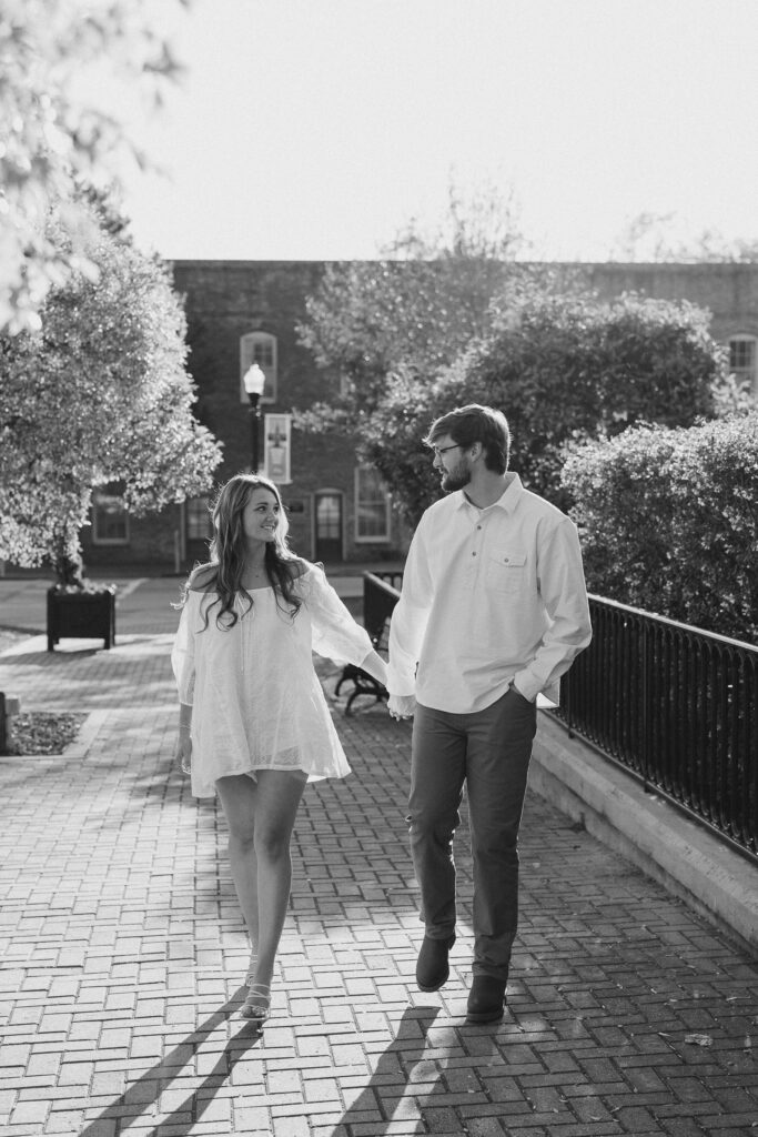 a couple having an engagement session in town park, madison, ga 