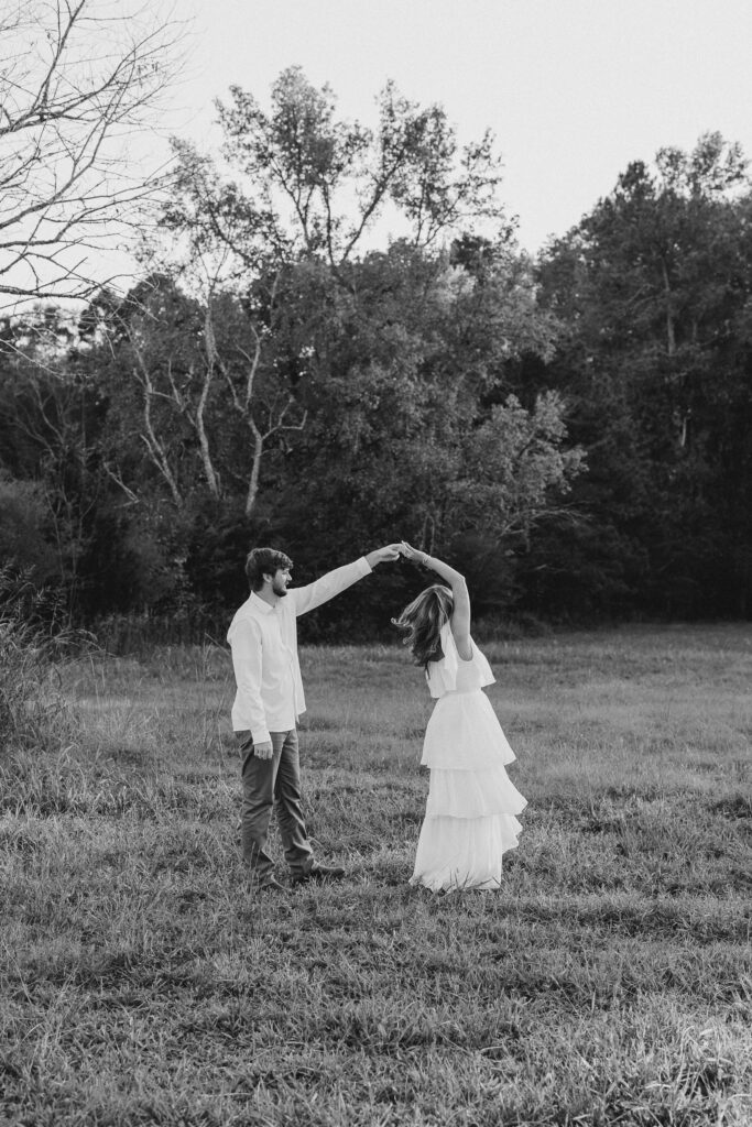 a couple having an engagement photography session in a field during golden hour