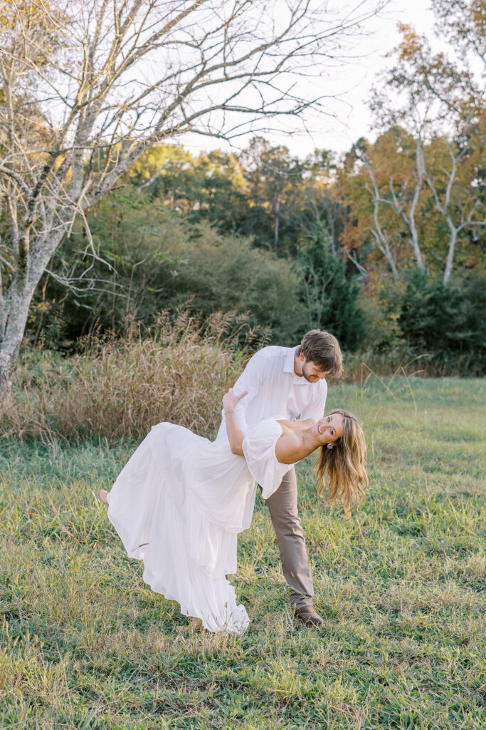 a couple having an engagement photography session in a field during golden hour