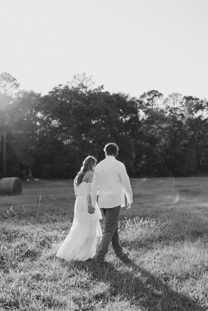 a couple having an engagement photography session in a field during golden hour