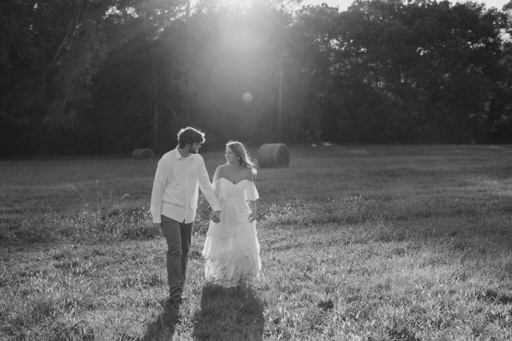 a couple having an engagement photography session in a field during golden hour