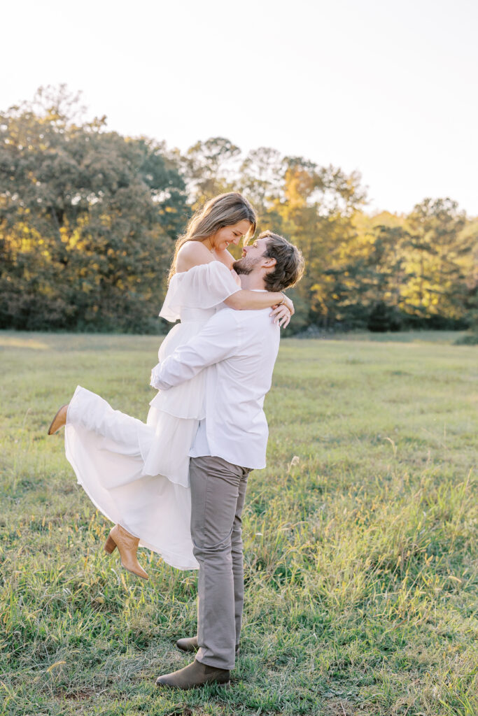 a couple having an engagement photography session in a field during golden hour