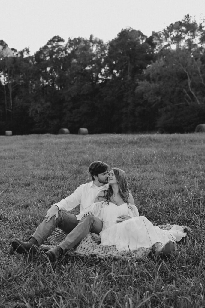 a couple having an engagement photography session in a field during golden hour