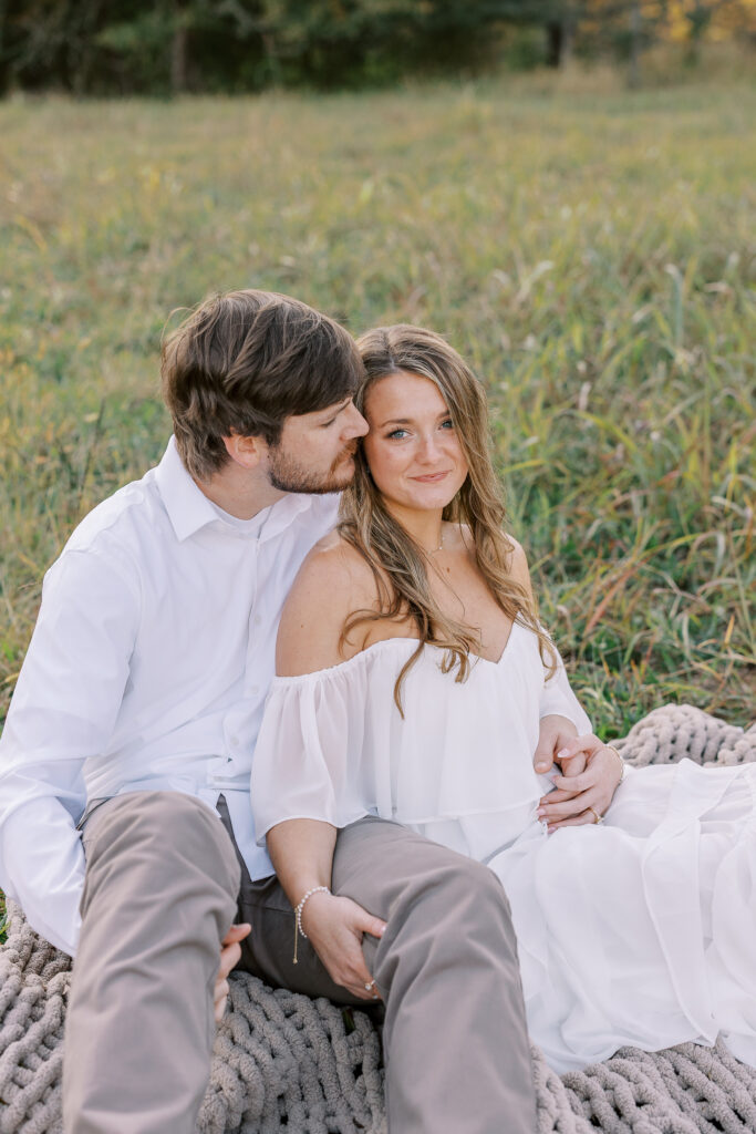 a couple having an engagement photography session in a field during golden hour