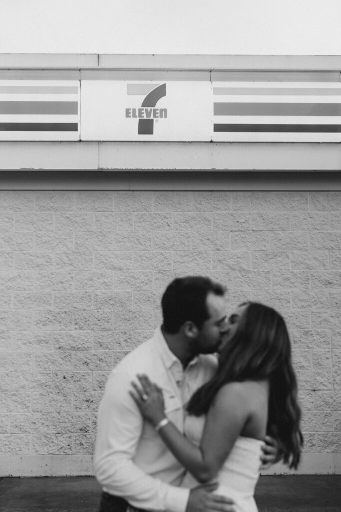 a couple taking a save the date photography session at the 7 Eleven gas station