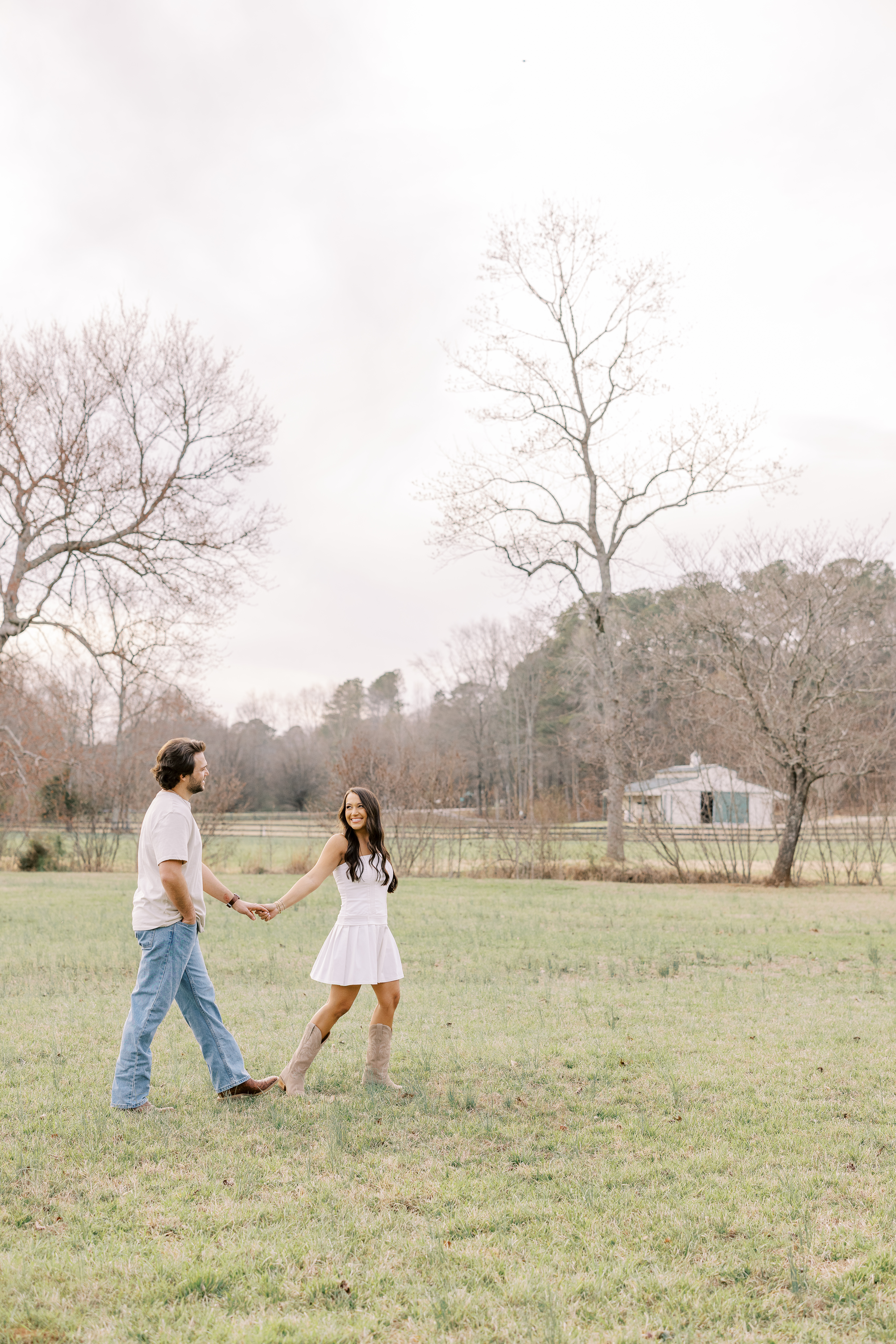 a couple having an engagement photoshoot in a field in georgia