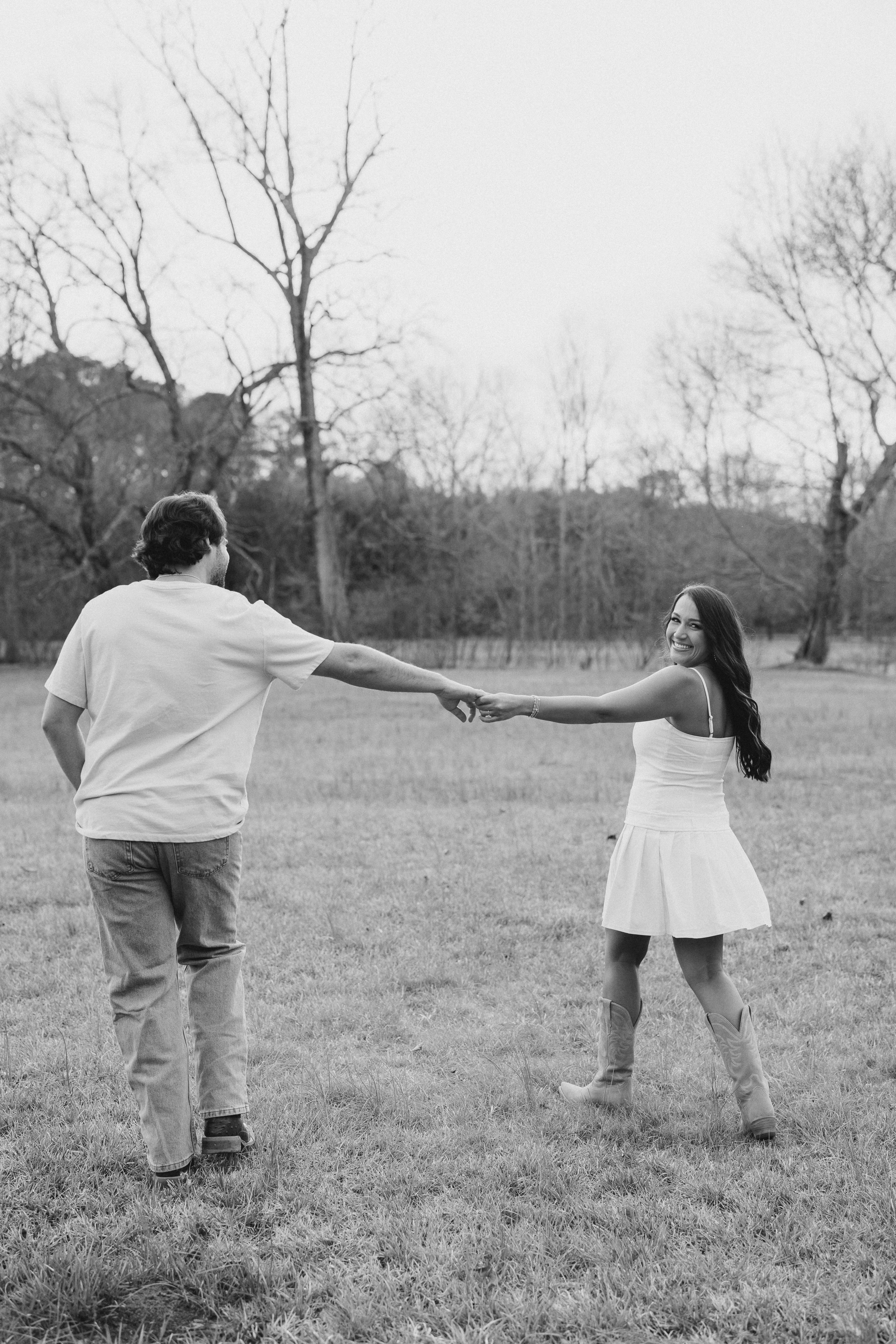 a couple having an engagement photoshoot in a field in georgia