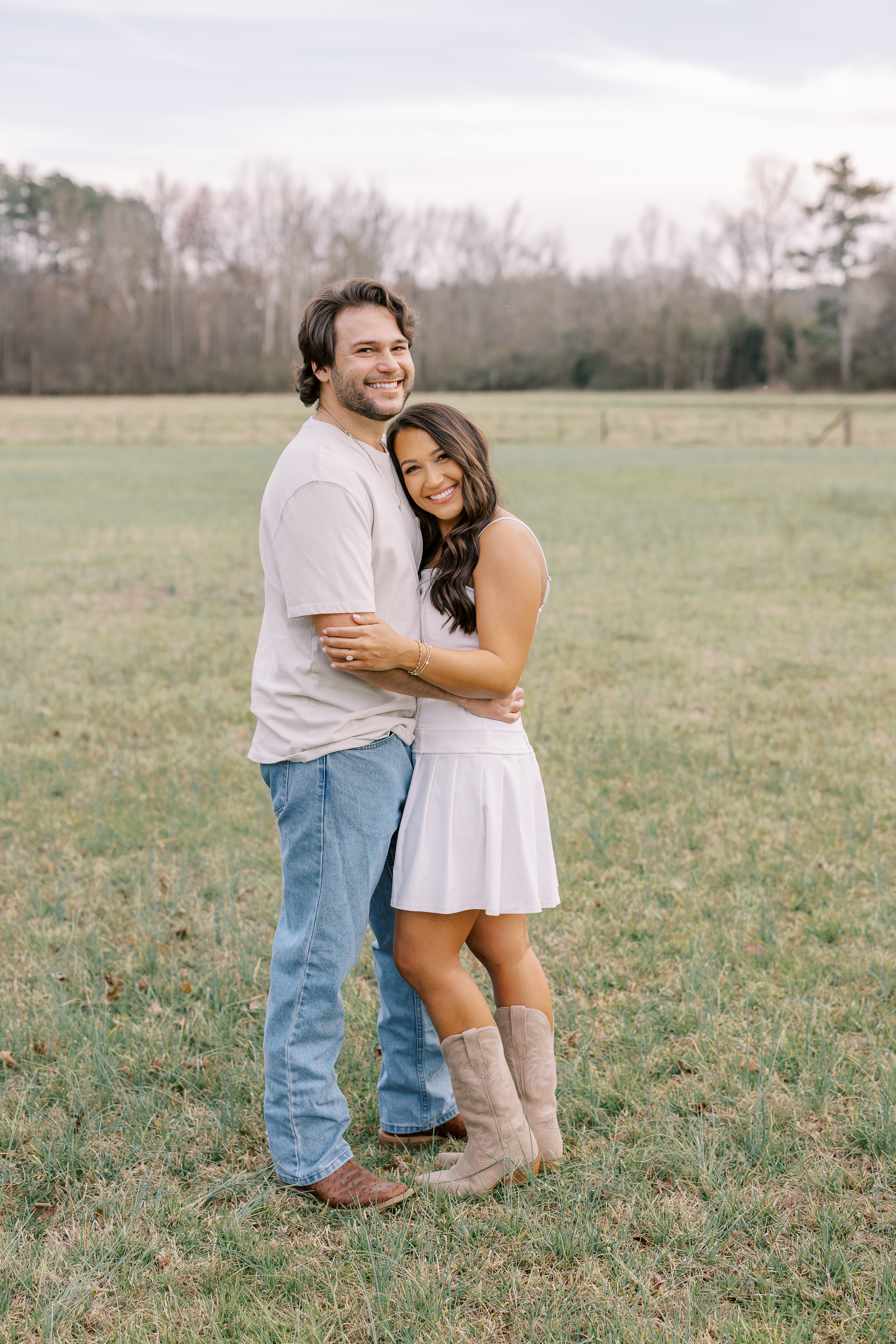a couple having an engagement photoshoot in a field in georgia