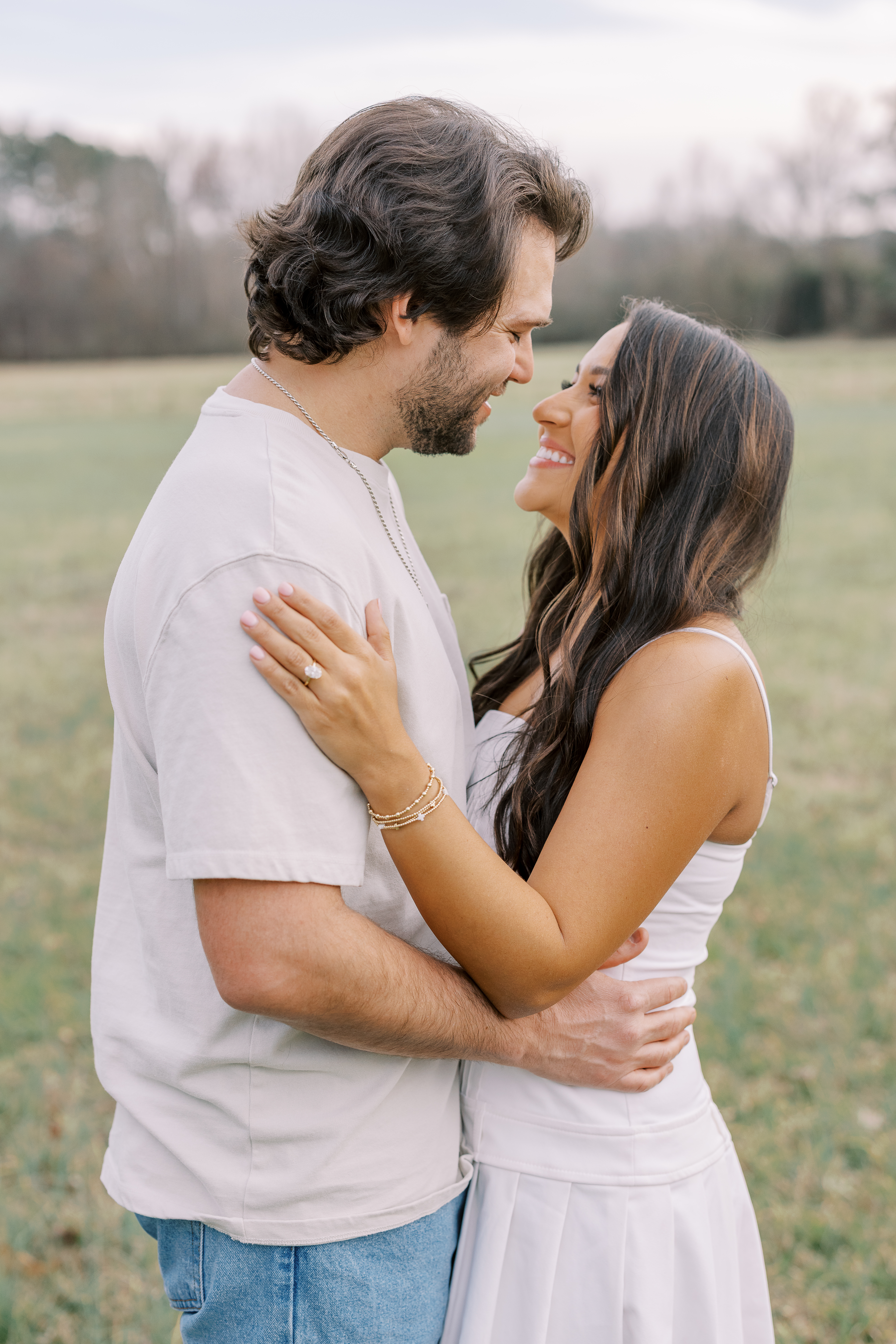 a couple having an engagement photoshoot in a field in georgia