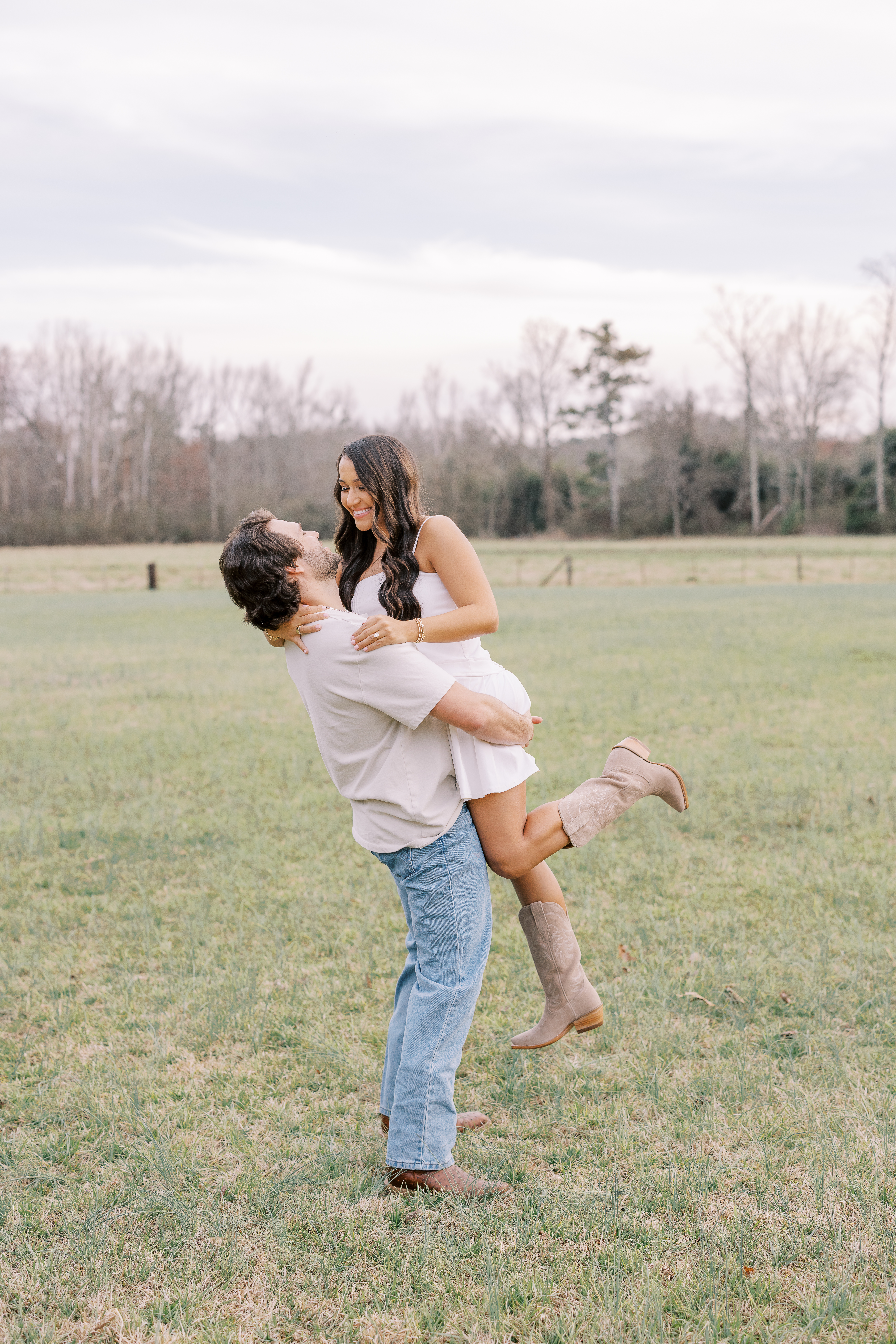 a couple having an engagement photoshoot in a field in georgia